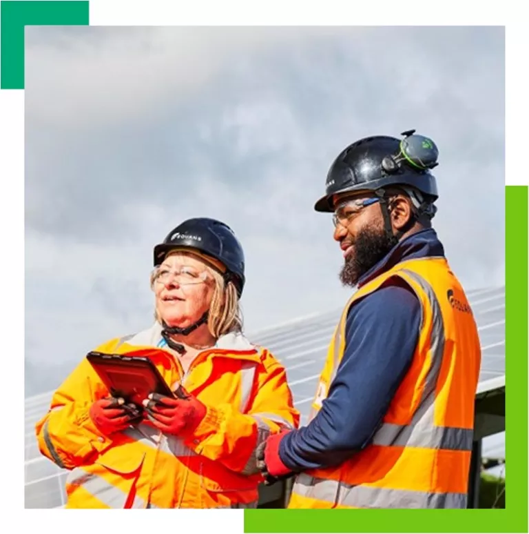 Equans employees on solar farm using tablet computer