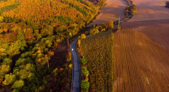 An aerial shot of an EV driving down a road