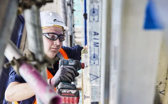 Equans employee installing wall insulation