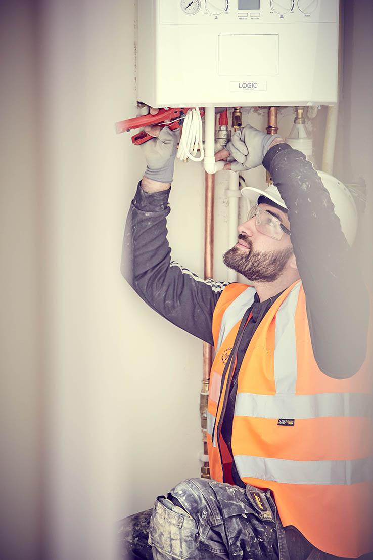 An equans employee checking a boiler