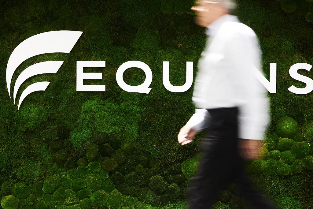 A gentleman walking past an Equans entrance sign