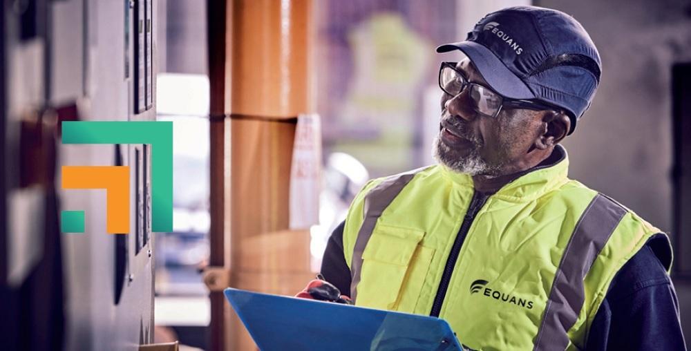 Equans employee holding clipboard reviewing onsite equipment