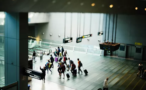 An aerial view of inside of airport, passengers walking towards departure gate