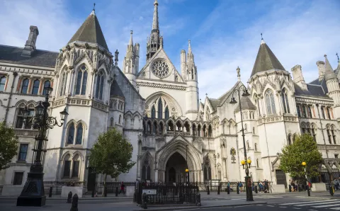 Bright afternoon view of the gothic architecture of the Royal Courts of Justice Building under blue sky in London, England, UK