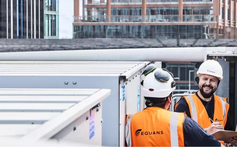 Equans employees stood on roof of building with PPE