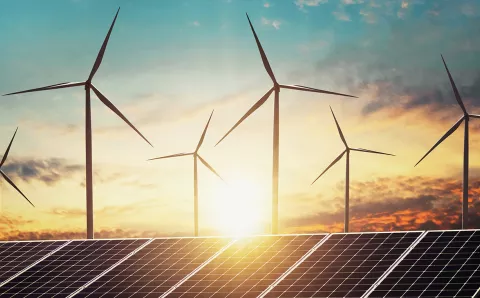 An image of renewable energy including wind turbines and solar panels