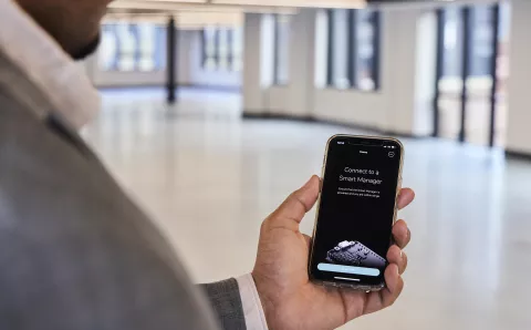 man using smart buildings app in office building