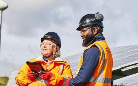Two Equans renewables employees in ground mounted solar field