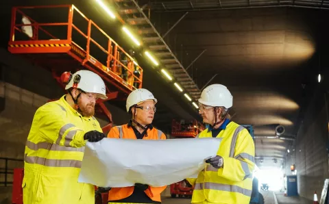 employees reviewing plans in road tunnel