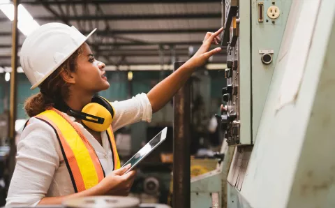 Industrial factory maintenance engineer woman inspecting relay protection system of machinery 